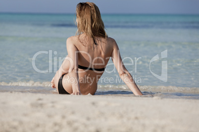 Junge Frau mit schwarzem Bikini am Strand im Wasser Querformat