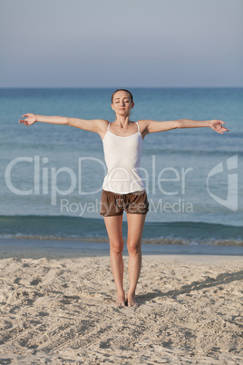 Frau macht yoga Sport am Strand Hochformat