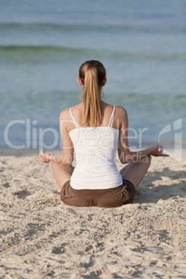 Frau macht yoga Sport am Strand Querformat