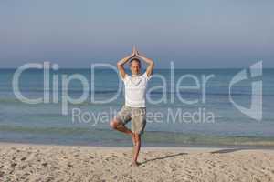 Mann macht yoga Sport am Strand Querformat