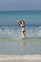 Frau mit Bikini im meer beim Springen Hochformat