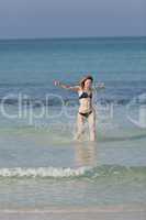 Frau mit Bikini im meer beim Springen Hochformat