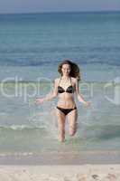 Frau mit Bikini im meer beim Springen Hochformat