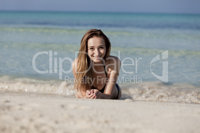 Junge Frau mit schwarzem Bikini am Strand im Wasser Querformat