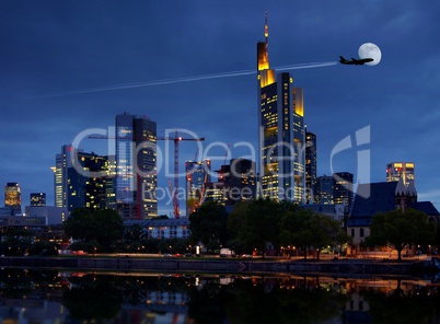 Skyline Frankfurt am Main zur blauen Stunde am Abend mit Flugzeug