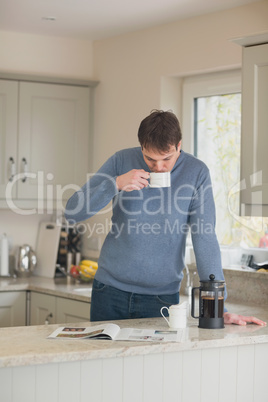 Young man having a coffee in the kitchen