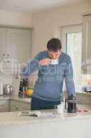 Young man having a coffee in the kitchen