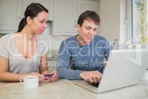 Man showing woman something on laptop