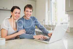 Happy young couple using laptop