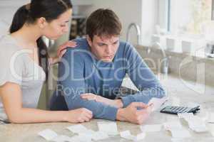Couple calculating bills in kitchen