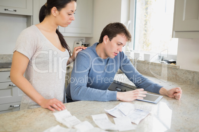 Couple using tablet pc to calculate finances