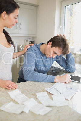 Wife comforting stressed husband over bills