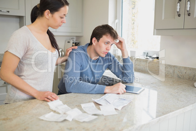 Two people using tablet pc to work out finances