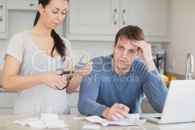 Disappointed woman cutting through a credit card