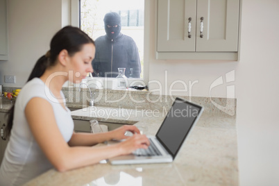 Burglar observing woman in the kitchen