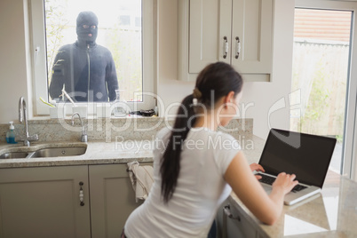 Woman being observed by burglar through window