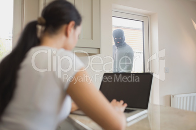 Burglar looking at woman through glass door