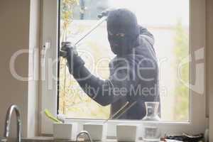 Burglar breaking a kitchen window