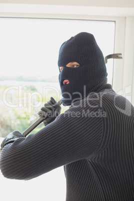 Robber holding a crowbar in his hands