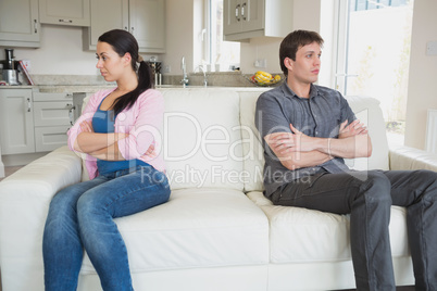 Two people sitting on the couch and having a dispute