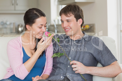 Man presenting flower to girlfriend