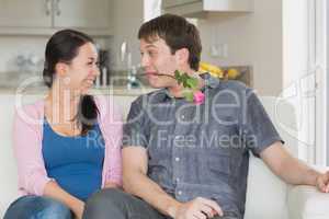 Man presenting a flower to the woman in his teeth