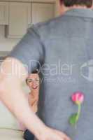 Man hiding flower behind his back for wife