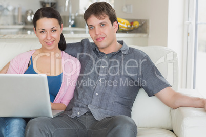 Two people relaxing while using the laptop