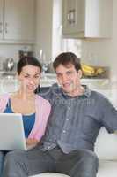 Young couple relaxing while using the laptop