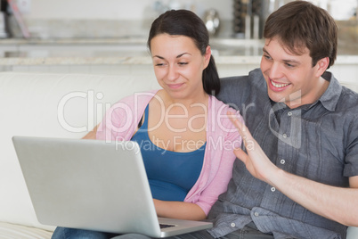 Two people using the laptop