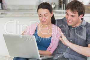 Two people using the laptop