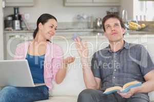 Couple relaxing with a laptop and a book