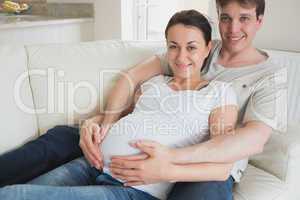 Expecting couple lying on couch
