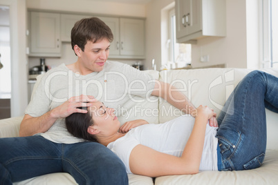 Pregnant woman lying on the couch with husband