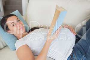 Young pregnant woman reading