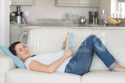 Pregnant woman reading on couch