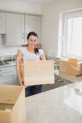 Smiling woman holding a moving box