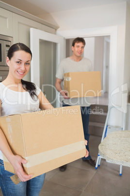 Young couple holding moving boxes