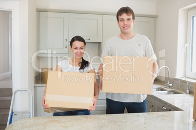 Young man and woman holding moving boxes