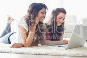 Two women relaxing at laptop
