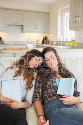 Girls sleeping while holding tablet computers
