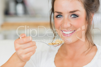 Smiling girl holding spoon of cereal