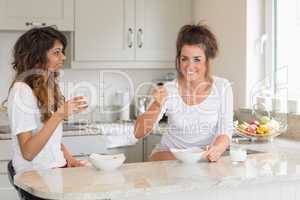 Two friends eating bowls of cereal