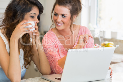 Girls chatting over coffee with laptop