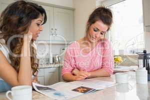 Friends looking at magazine and having coffee