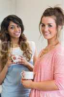Smiling women holding coffee cups