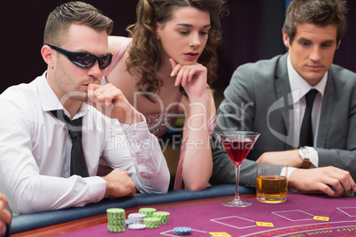 Men and woman sitting at poker table