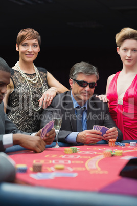 Man in sunglasses smiling at poker table