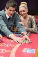 Man winning at poker with woman next to him