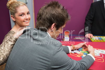 Woman smiling as man is taking winnings